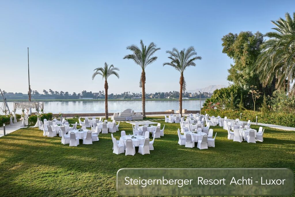 Gepflegte Gartenanlage mit festlich gedeckten Tischen und Blick auf den Nil im Steigenberger Resort Achti in Luxor, Ägypten.